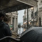 Pluie biarritz : couple sous imperméables, smartphone météo, rue mouillée près des Halles